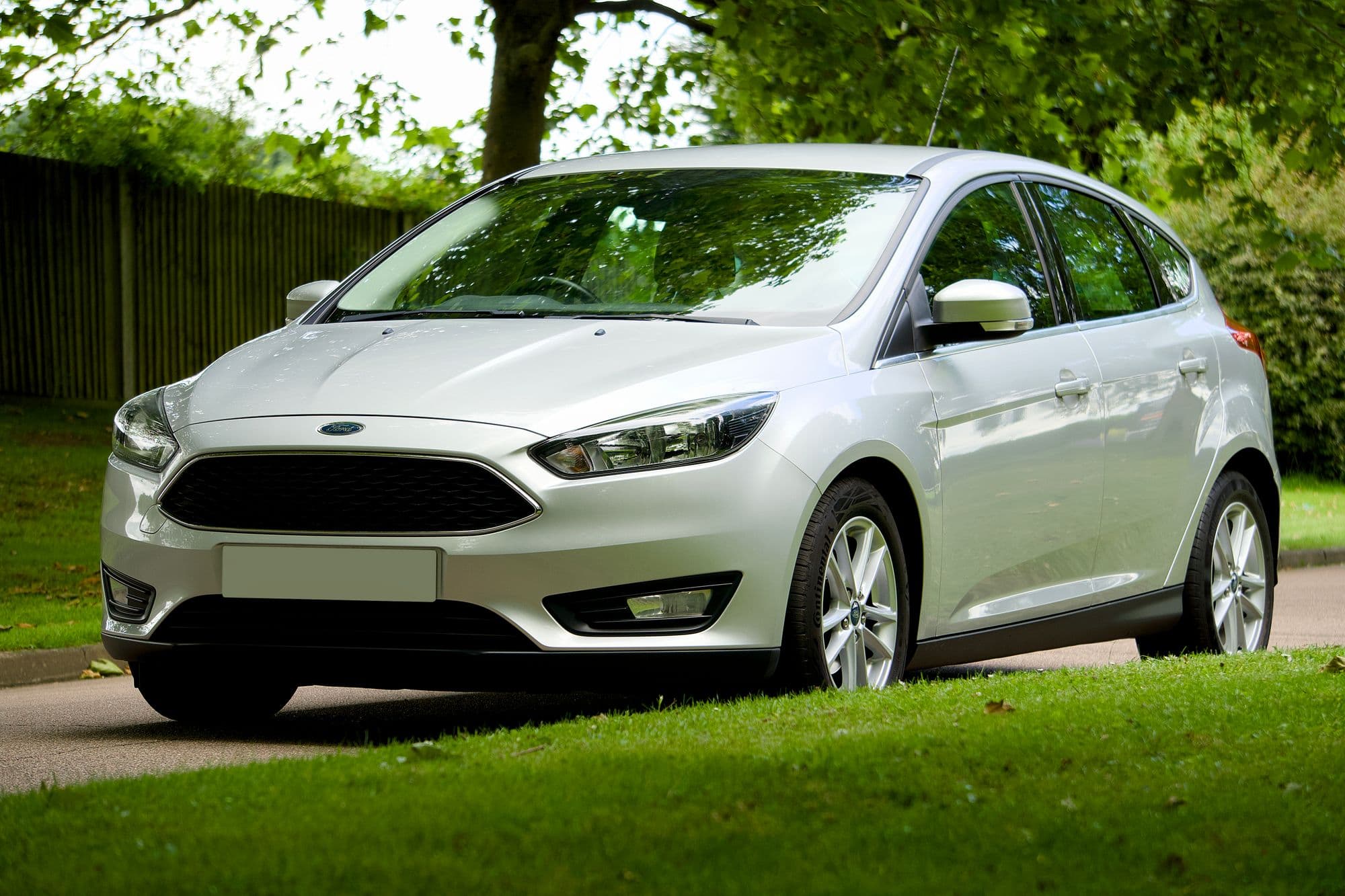 A silver hatchback parked on a leafy street, photographed from the front three-quarter angle